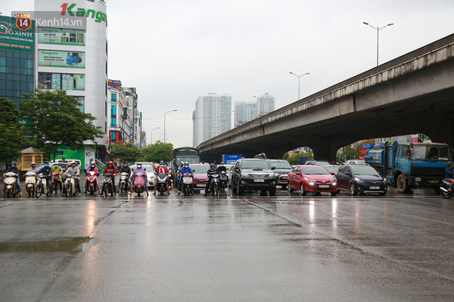 Ảnh: Đường phố Hà Nội và Sài Gòn đông đúc trong ngày đầu tiên nới lỏng cách ly xã hội, người dân thủ đô chật vật đi làm dưới mưa - Ảnh 2.