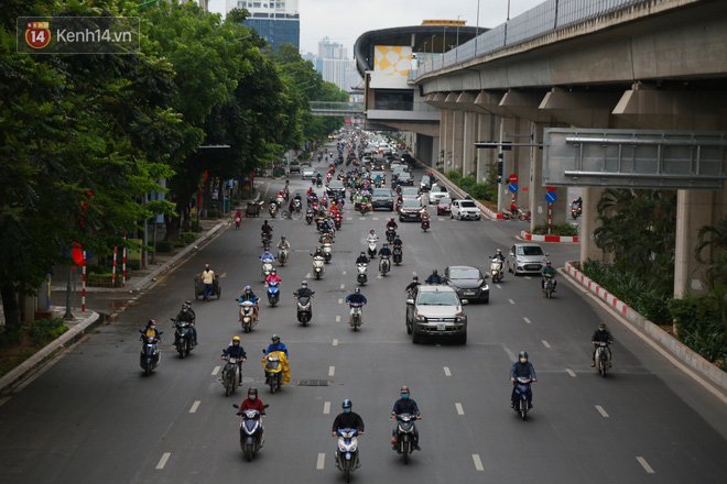 Ảnh: Đường phố Hà Nội và Sài Gòn đông đúc trong ngày đầu tiên nới lỏng cách ly xã hội, người dân thủ đô chật vật đi làm dưới mưa - Ảnh 3.