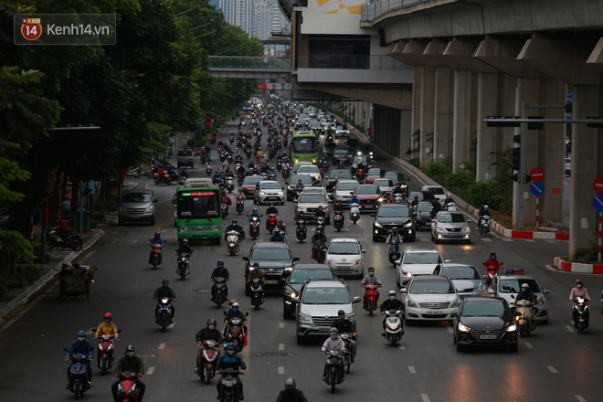 Ảnh: Đường phố Hà Nội và Sài Gòn đông đúc trong ngày đầu tiên nới lỏng cách ly xã hội, người dân thủ đô chật vật đi làm dưới mưa - Ảnh 6.