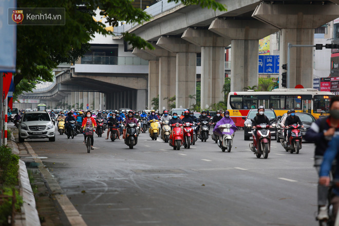 Ảnh: Đường phố Hà Nội và Sài Gòn đông đúc trong ngày đầu tiên nới lỏng cách ly xã hội, người dân thủ đô chật vật đi làm dưới mưa - Ảnh 7.