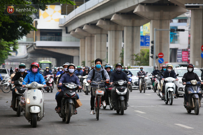 Ảnh: Đường phố Hà Nội và Sài Gòn đông đúc trong ngày đầu tiên nới lỏng cách ly xã hội, người dân thủ đô chật vật đi làm dưới mưa - Ảnh 8.