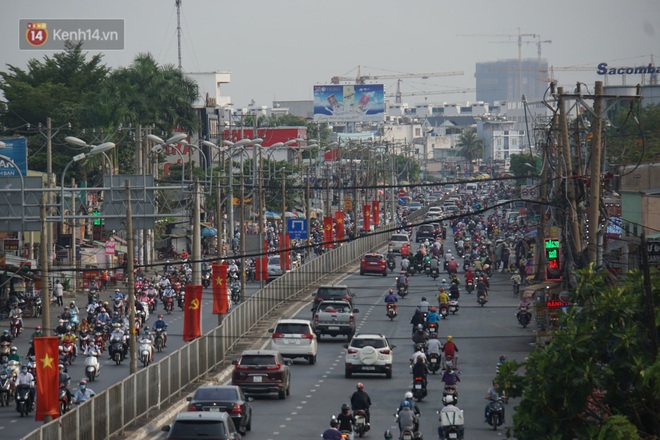 Ảnh: Đường phố Hà Nội và Sài Gòn đông đúc trong ngày đầu tiên nới lỏng cách ly xã hội, người dân thủ đô chật vật đi làm dưới mưa - Ảnh 13.