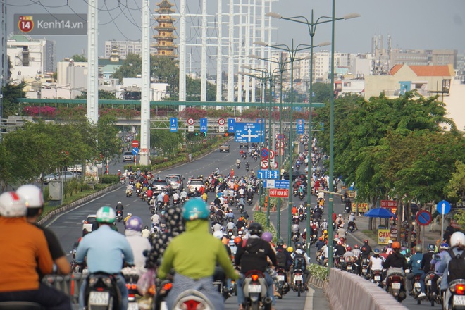 Ảnh: Đường phố Hà Nội và Sài Gòn đông đúc trong ngày đầu tiên nới lỏng cách ly xã hội, người dân thủ đô chật vật đi làm dưới mưa - Ảnh 11.