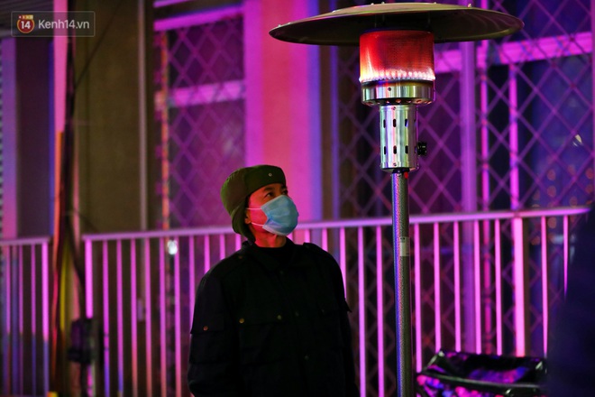 Người dân quây quần dưới 20 cây sưởi tỏa nhiệt trong bệnh viện giữa đêm đông buốt giá ở Hà Nội: Màn trời chiếu đất trông người bệnh, giờ đã ấm hơn rồi - Ảnh 7.