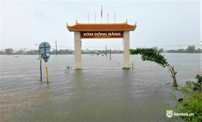Ảnh: Đường quốc lộ ở Quảng Nam thành sông, dân lội nước ngập ngang bụng để về nhà - Ảnh 4.