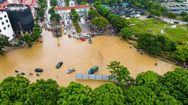 Ảnh: Đại lộ Thăng Long ngập sâu trong nước, hàng nghìn người dân vất vả dắt xe đi làm - Ảnh 2.