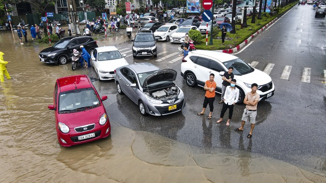 Ảnh: Đại lộ Thăng Long ngập sâu trong nước, hàng nghìn người dân vất vả dắt xe đi làm - Ảnh 10.