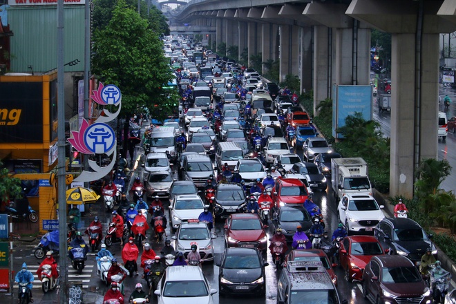 Đường phố Hà Nội ùn tắc nghiêm trọng trong ngày mưa lớn, người dân vất vả di chuyển đi học, đi làm - Ảnh 1.