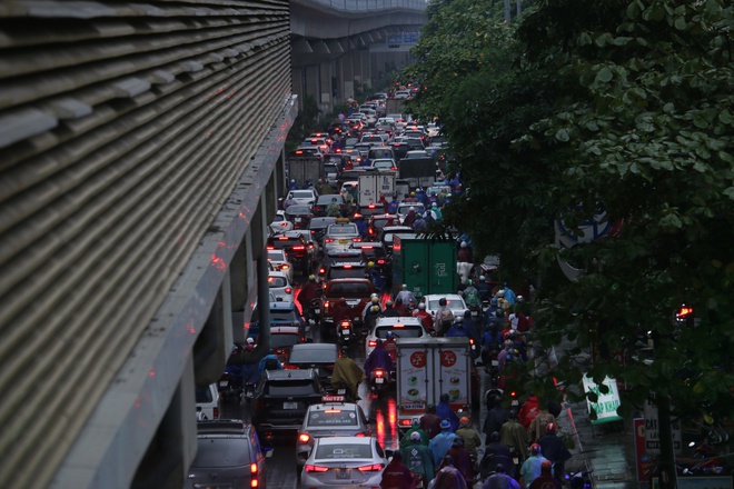 Đường phố Hà Nội ùn tắc nghiêm trọng trong ngày mưa lớn, người dân vất vả di chuyển đi học, đi làm - Ảnh 2.