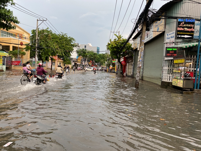 TP.HCM: Mưa như trút nước ngày cuối tuần, nhiều hàng quán đóng cửa sớm vì đường ngập nặng - Ảnh 2.