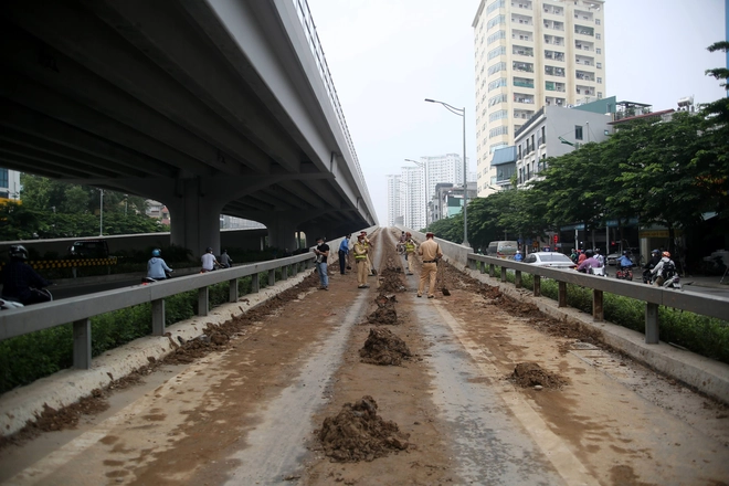 Cảnh sát giao thông vất vả dọn dẹp đất rơi vãi tại tuyến đường cao tốc đẹp nhất Hà Nội - Ảnh 2.