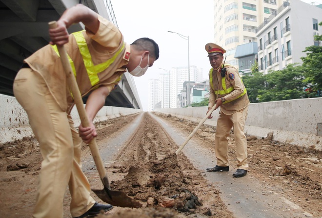 Cảnh sát giao thông vất vả dọn dẹp đất rơi vãi tại tuyến đường cao tốc đẹp nhất Hà Nội - Ảnh 6.