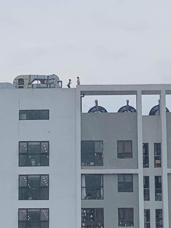 Hai cháu nhỏ chơi đùa trên tầng tum chung cư ở Hà Nội - Ảnh 1.